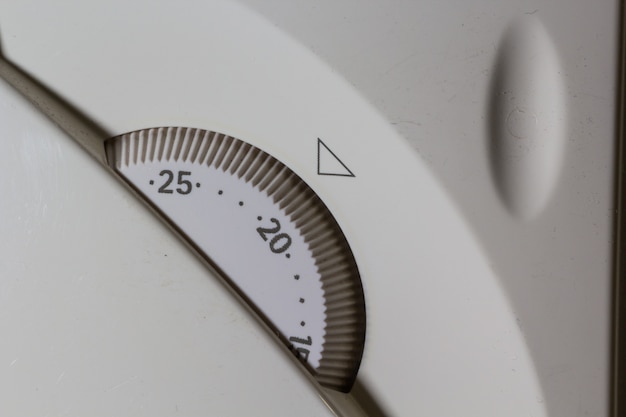 Foto gratuita colpo del primo piano del pannello di controllo della temperatura bianco per il sistema di riscaldamento centralizzato