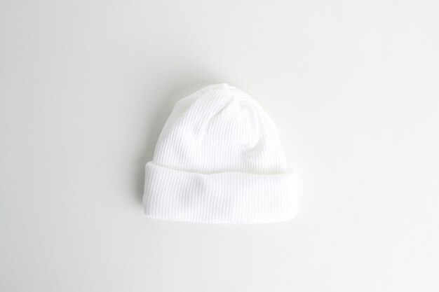 白い背景で隔離の白いウールの赤ちゃん帽子のクローズアップショット
