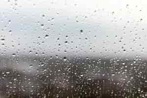 Free photo closeup shot of a window on a rainy day, raindrops rolling down the window