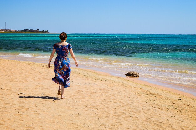 화창한 날 해변을 걷는 여성의 클로즈업 샷