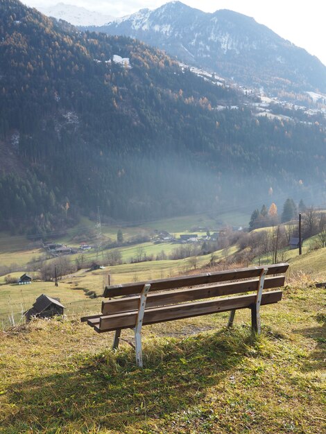 Closeup shot of a wooden bench with a big mountain