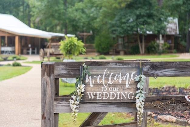 「私たちの結婚式へようこそ」と書かれた木製のフェンスのクローズアップショット