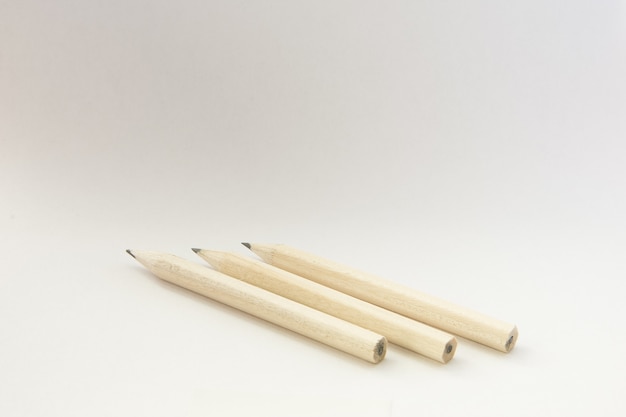 Colpo del primo piano delle matite di legno su un muro bianco isolato