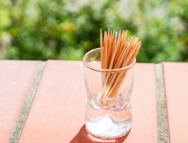 Closeup shot of wooden toothpicks in a small glass