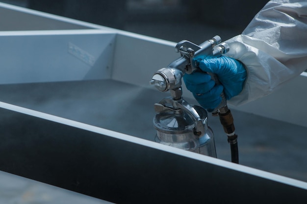 Free photo closeup shot of a worker in protective gloves painting wooden details