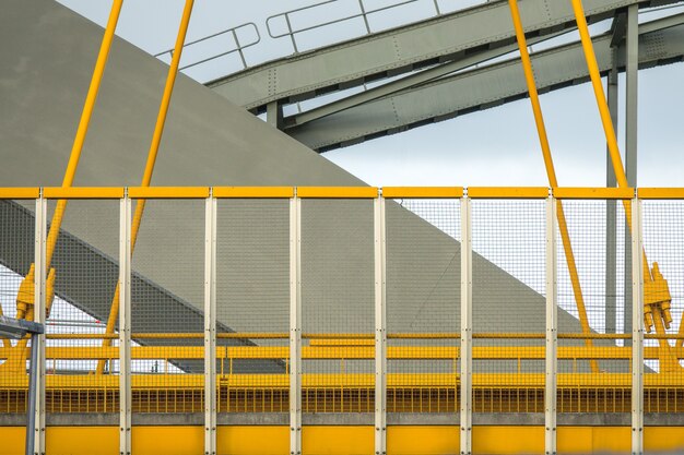 Closeup shot of the yellow and grey fragments of a modern bridge