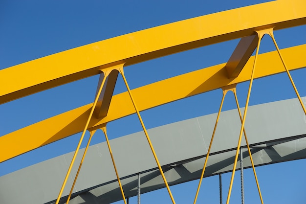 Free photo closeup shot of a yellow metal arch under a blue sky