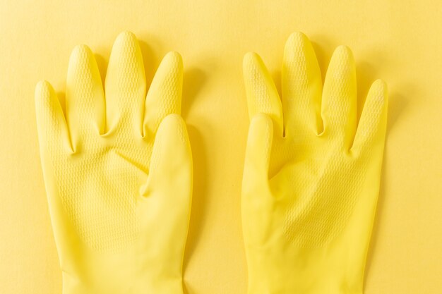 黄色の表面に黄色のプラスチック手袋のクローズアップショット