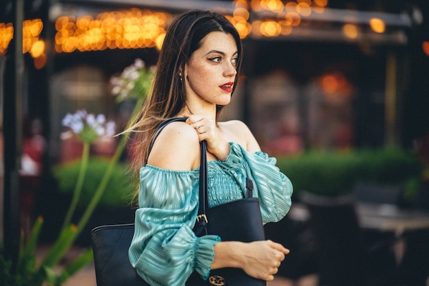 Closeup shot of a young European female in a turquoise blouse