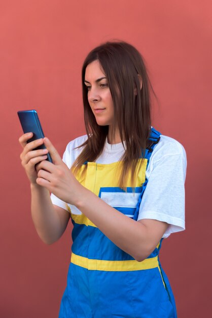 彼女のスマートフォンがカメラにポーズをとって若い女性のクローズアップショット