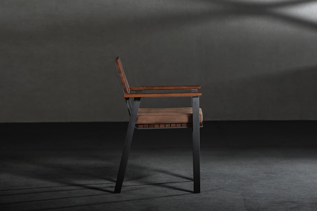 Closeup of a simple modern chair with metallic legs in a room with gray walls