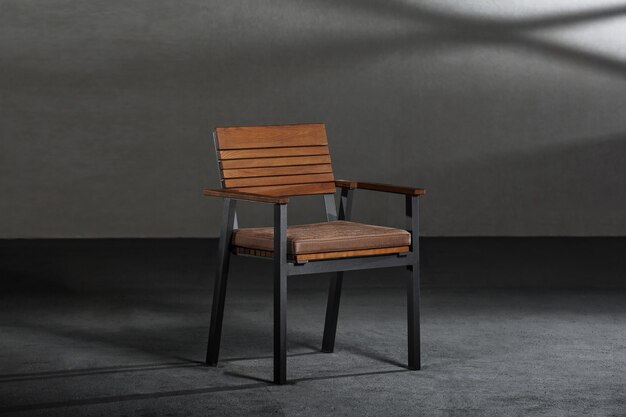 회색 벽이 있는 방에 금속 다리가 있는 단순하고 현대적인 의자 클로즈업