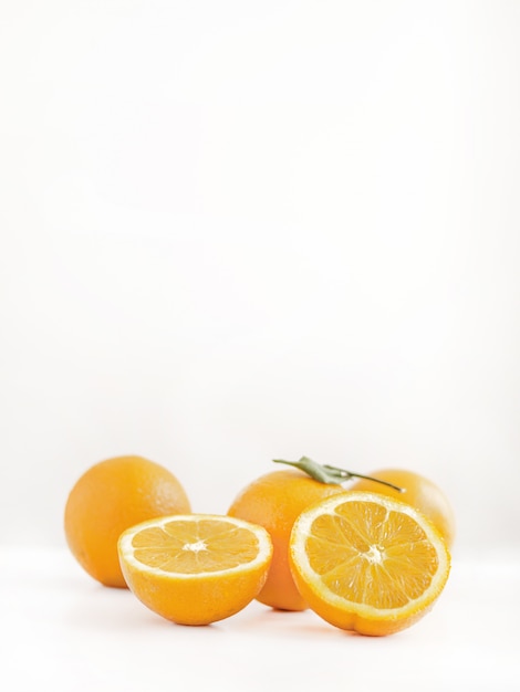 Free photo closeup of sliced and whole oranges on a beautiful light