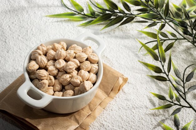 Closeup of a small bowl of chickpeas decorated with plant branches