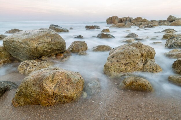 Closeup of the small rocks on the shore against the horizon