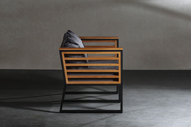 Closeup of a small wooden chair with a gray cushion on it in a room