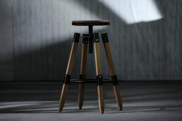 Closeup of a small wooden round-shaped bedside table with a blurry background