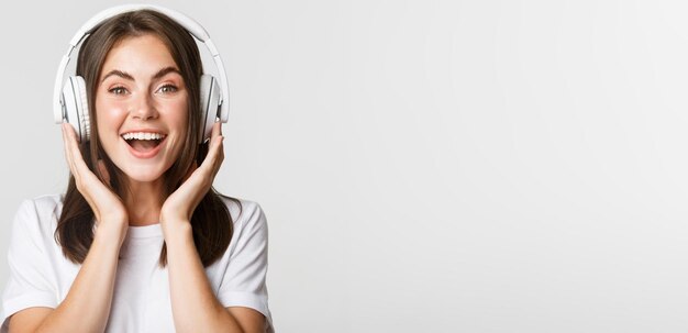 Closeup of smiling attractive brunette girl listening music in headphones enjoying interesting podca