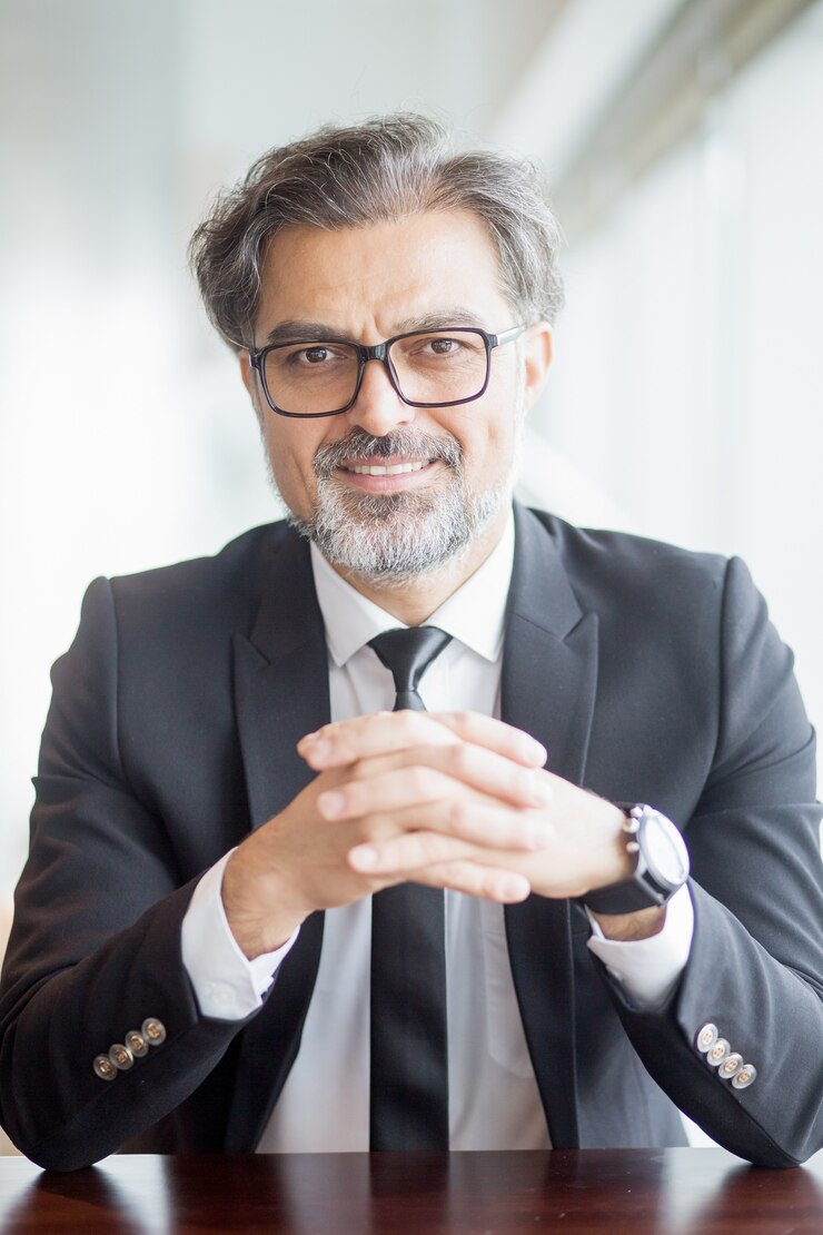 Free Photo closeup of smiling business leader sitting at table