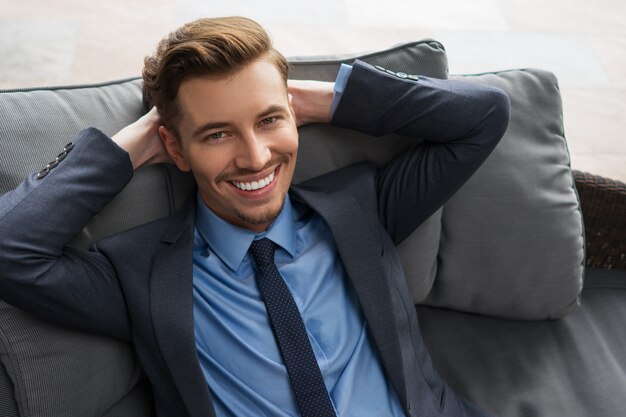 Closeup of Smiling Businessman Resting on Cushions