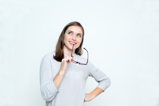 Closeup of Smiling Dreamy Woman Biting Glasses Arm