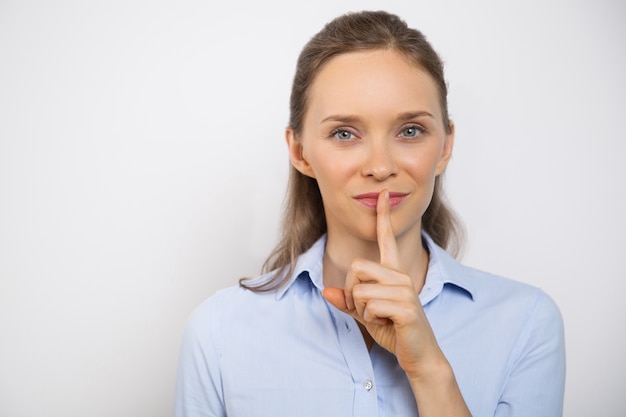 Closeup of Smiling Woman Making Silence Gesture