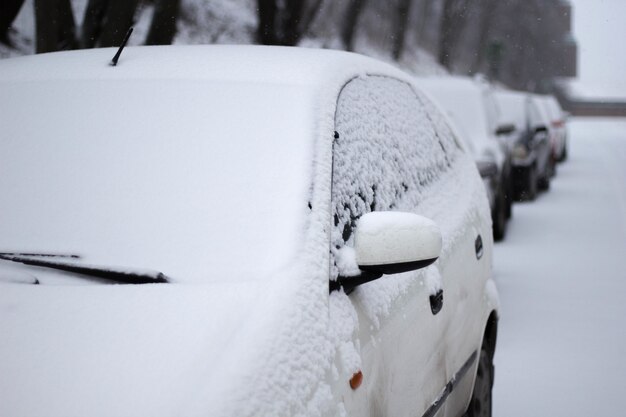겨울 동안 거리에 눈 덮인 자동차의 근접 촬영