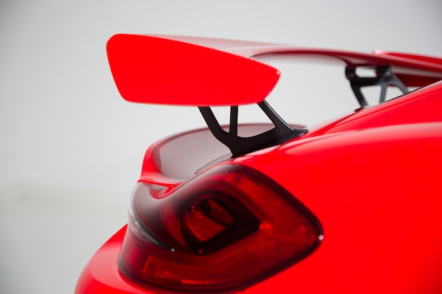 Крупным планом спойлер на красном современном спортивном автомобиле под изолированными огнями