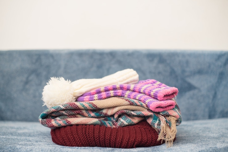 Free Photo closeup of stacked warm winter clothes
