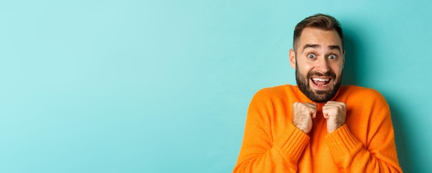 Free photo closeup of startled man gasping and pressing hands to chest staring at camera shocked standing over