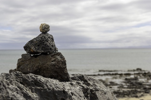 Closeup of stones on top of each other with the sea in Lanzarote in Spain