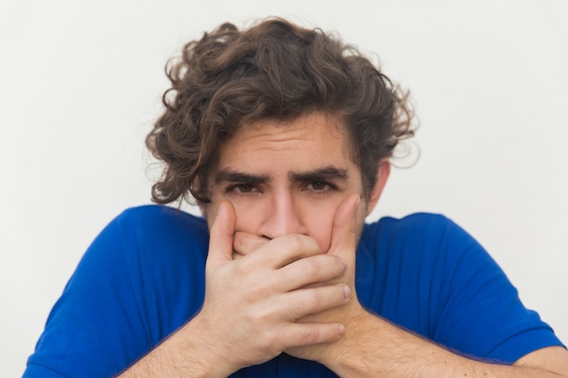 Closeup of stressed guy covering mouth