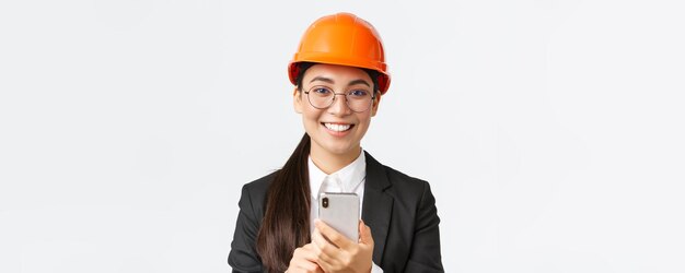 Closeup of successful female chief engineer construction architect in safety helmet and business sui