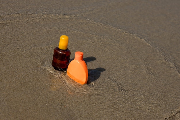 Premium Photo | Closeup of sunscreen protection set on sandy beach at  tropical seaside on warm sunny day skin care c