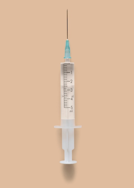 Closeup of a syringe on a brown background