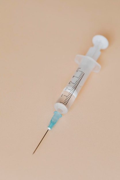 Closeup of a syringe on a brown background