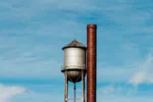 Free photo closeup of a tall water tower with a metal large pipe next to it