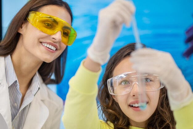 Closeup of teacher and girl with test tube