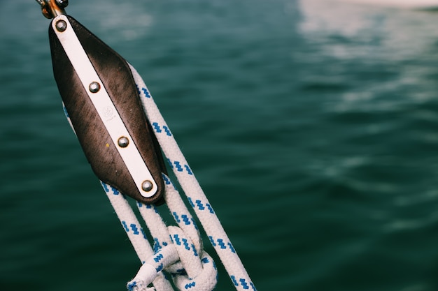 Foto gratuita primo piano delle corde strette su un peschereccio con un mare vago
