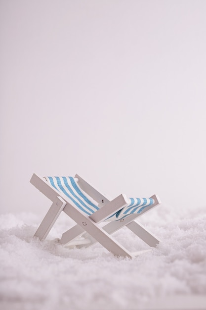 Closeup of a tiny toy sunbed in the snow