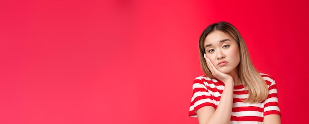 La ragazza stanca del primo piano esprime la noia dell'apatia che sospira riluttante guarda la fotocamera magra del palmo della faccia che cade aslee