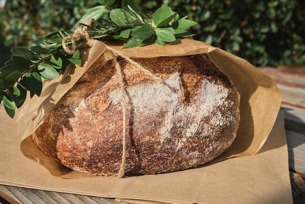 Free photo closeup of traditional round bread on craft paper package decorated with branch at christmas market