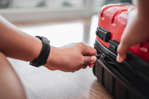 Closeup of traveler man have finished packing and is locking them Man is preparing clothes in suitcases Travel holiday and vacation concept