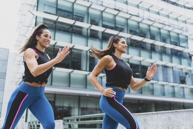 두 명의 매력적인 여성이 달리고 운동을 하는 모습 - 피트니스와 스포츠의 개념