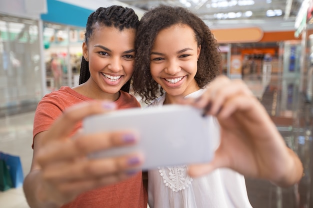 Foto gratuita closeup di due ragazze nere prendendo selfie nel centro commerciale