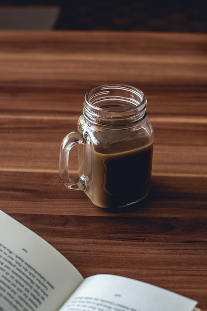 Free photo closeup vertical shot of a glass cup of hot chocolate on a wooden table