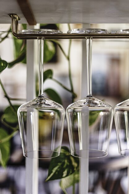 Closeup vertical shot of wine glasses hanging on a rack