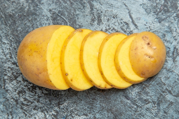 Vista del primo piano di fette di patate con la buccia deliziose facili sulla tabella grigia