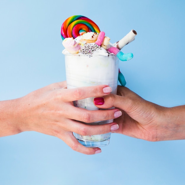 Closeup view of hands holding delicious milkshake