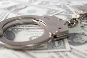 Free photo closeup view of metal handcuffs and dollars